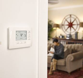 White Smart Thermostat Placed On A White Wall